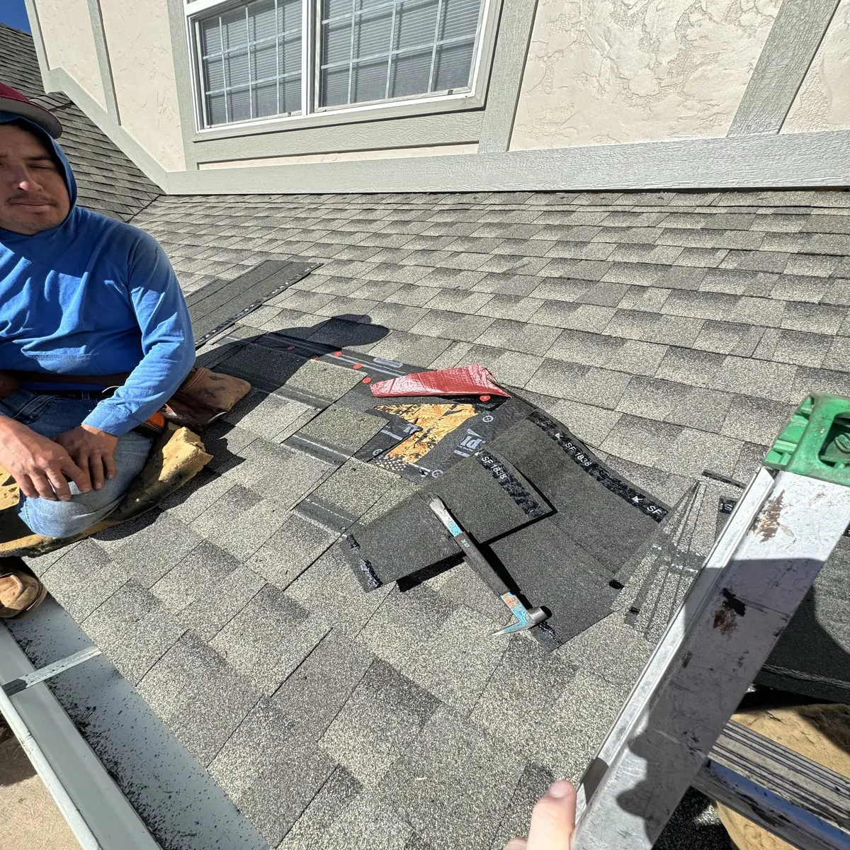 Professional roof repair work showing damaged shingles being replaced by Spencer Roofing team